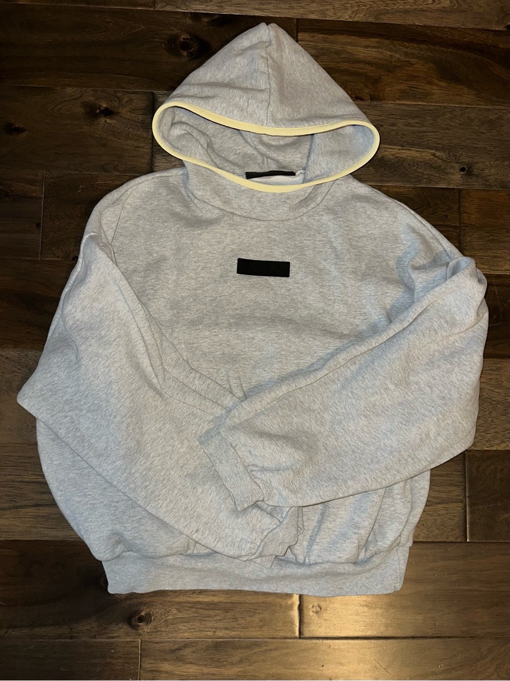 Essentials Light Gray Hooded Sweatshirt with Cream Trim and Black Patch